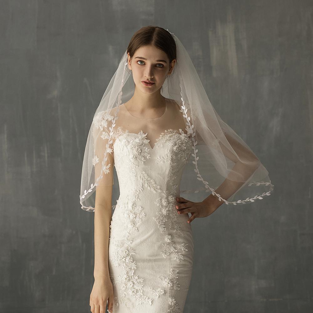Bride wearing the Florence white botanical leaf edge bridal veil with a romantic lace wedding gown