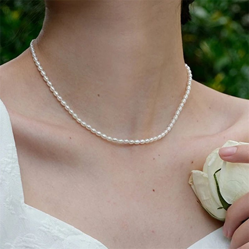 The Audrey faux pearl strand necklace worn with a white bridal outfit outdoors