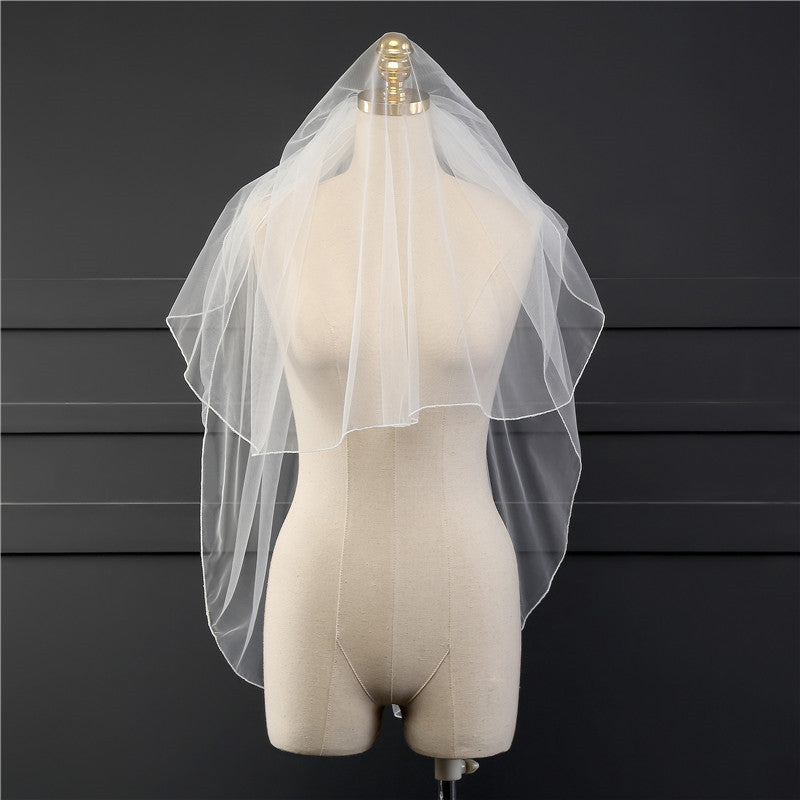 Front view of the Elise sheer bridal veil with a hair comb displayed on a dress form