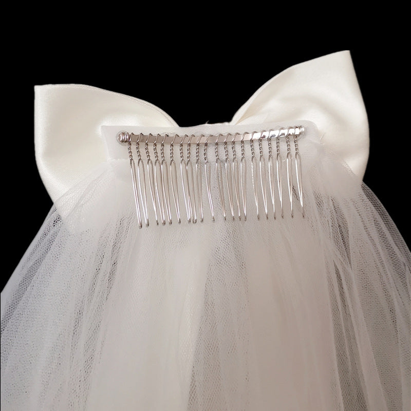 Back view of the Colette bridal bow veil showing the gathered mesh and attachment area beneath the bow