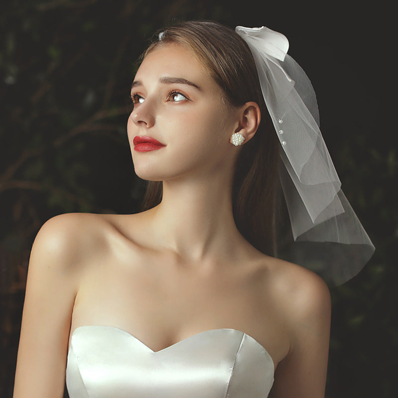 Juliette beige mini bridal veil with pearl-accented satin-style bow