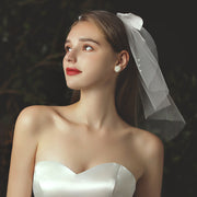 Juliette beige mini bridal veil with pearl-accented satin-style bow