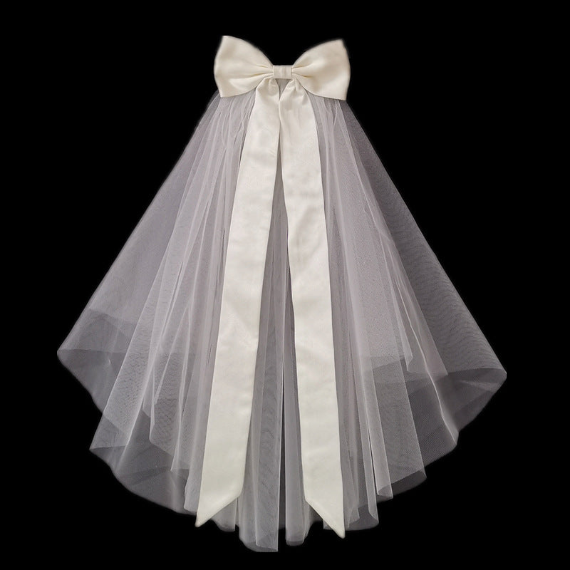 Colette short bridal veil with layered sheer mesh and long satin-style bow ribbons against a black background