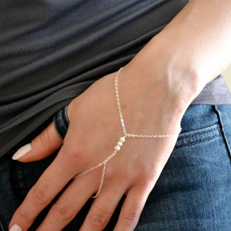 Amelie delicate silver-tone hand chain bracelet connecting the wrist and finger, styled with casual clothing