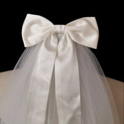 Close-up of the Colette oversized satin-style bridal bow with soft mesh veil and flowing ribbon tails