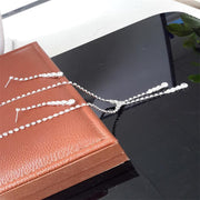 Silver-tone Seraphina tassel necklace and matching earrings displayed beside a brown jewelry box