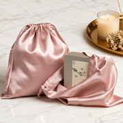 Blush satin gift bags styled beside a candle