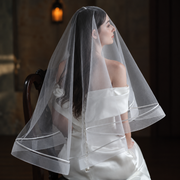 Cinematic bridal portrait featuring the Celeste satin-trim double-layer veil