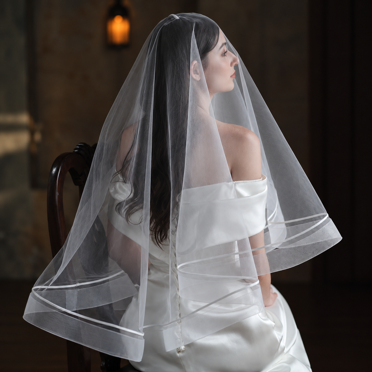 Cinematic bridal portrait featuring the Celeste satin-trim double-layer veil