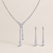 Seraphina bridal jewelry set featuring a silver-tone Y-shaped tassel necklace and matching earrings on a beige background