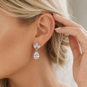 Model wearing Isla crystal teardrop bridal earrings with silver-tone leaf details