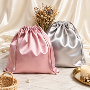 Elegant satin drawstring gift pouches arranged on marble
