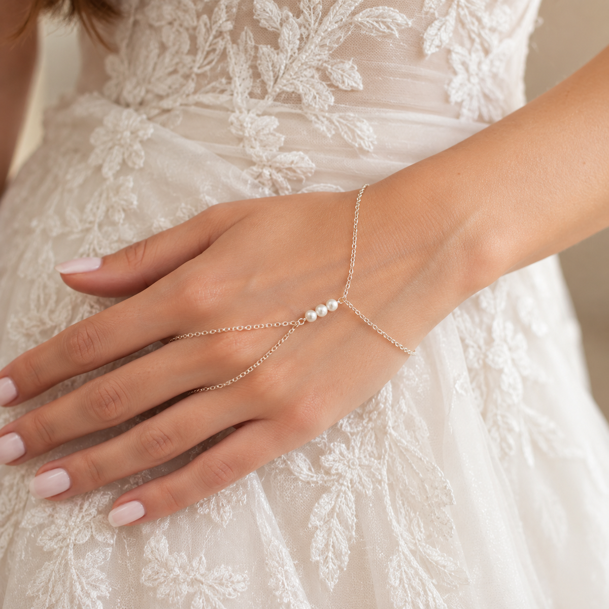 Bride wearing the Amelie pearl-inspired hand chain bracelet over an ivory lace wedding dress