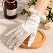 Romantic still life of ivory-toned satin bridal gloves