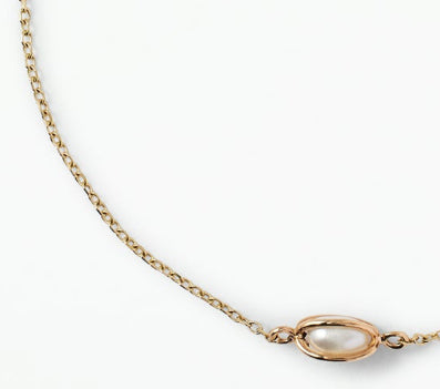 Close-up of the Margot gold-tone bracelet featuring a delicate chain and polished oval centerpiece