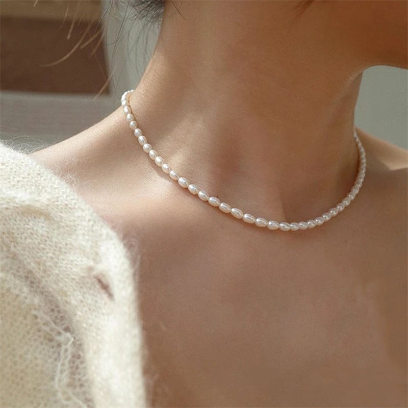 The Audrey minimalist white pearl-inspired necklace worn with a neutral outfit