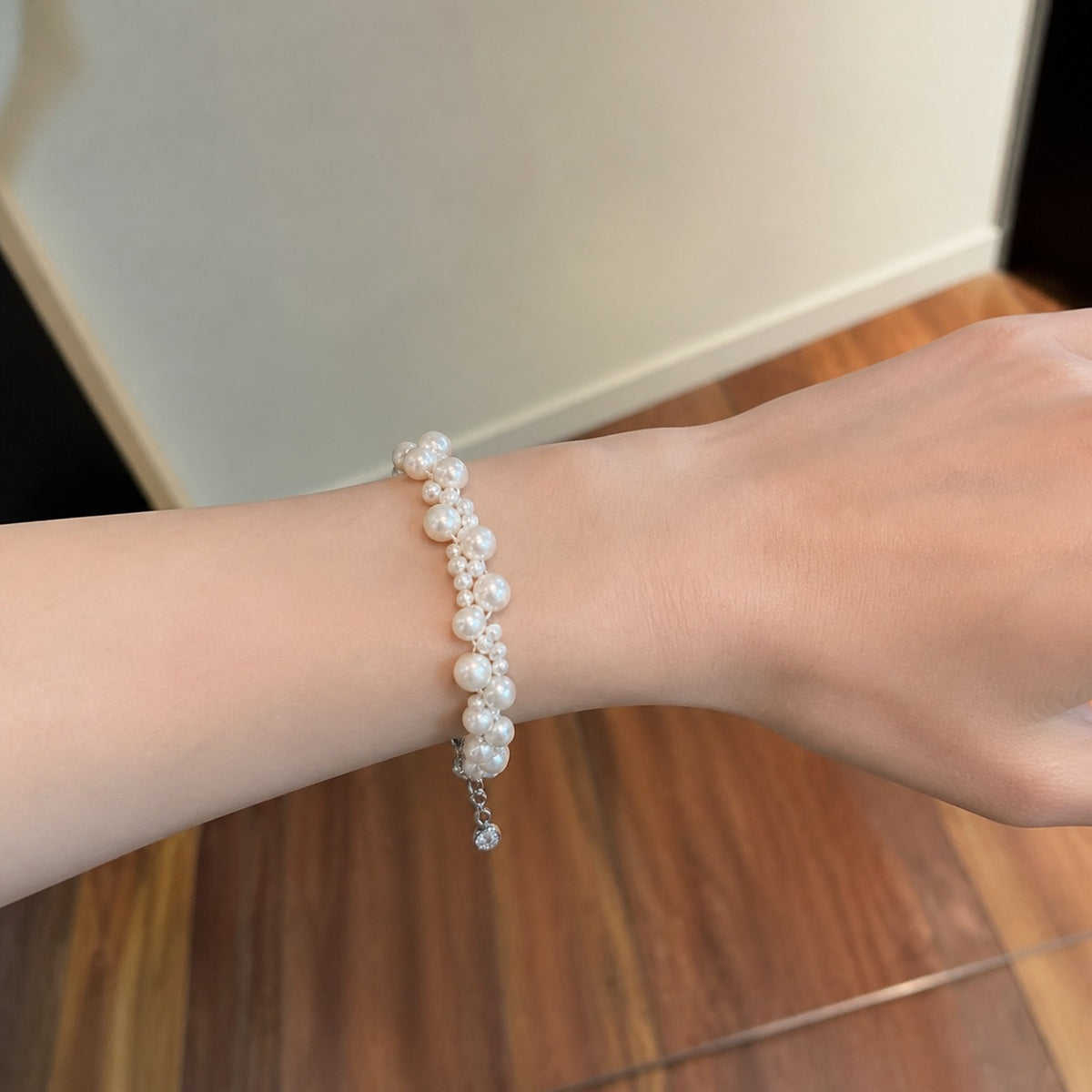 Rosalie pearl bridal bracelet worn on wrist against a warm wooden background