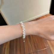 Rosalie pearl bridal bracelet worn on wrist against a warm wooden background