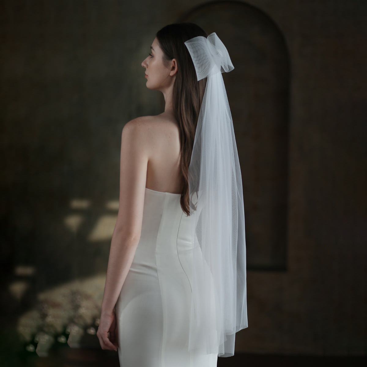 Side view of the Noelle oversized bow bridal veil styled with a minimalist white wedding dress