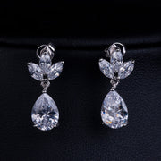 Isla dangling teardrop clip on earrings with sparkling leaf-shaped stones on a dark background
